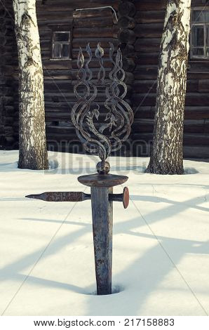 Forged a pointer handmade, set in the snow-covered ground.