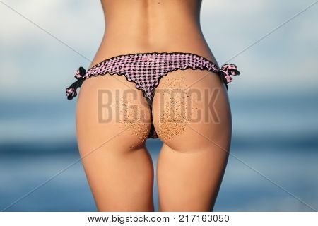 Beautiful young girl with a sexy ass on the beach