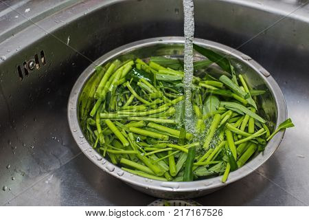 Fresh vegetables under water on a bowl