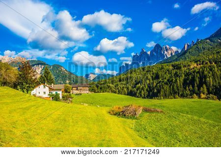 The valley is surrounded by a dentate wall of dolomite rocks. Warm autumn in the Dolomites, the Val de Funes. The concept of ecological tourism