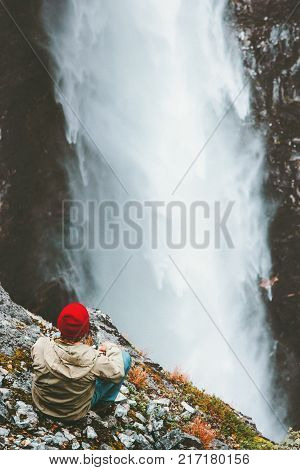 Traveling Man relaxing on cliff enjoying waterfall Vettisfossen view outdoor Travel Lifestyle success concept adventure vacations in Norway wild nature