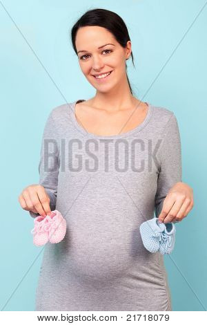 Fotografie ženy, která je těhotná, držení miminka, růžová pro dívky a pro chlapce modrá 32 týdnů.