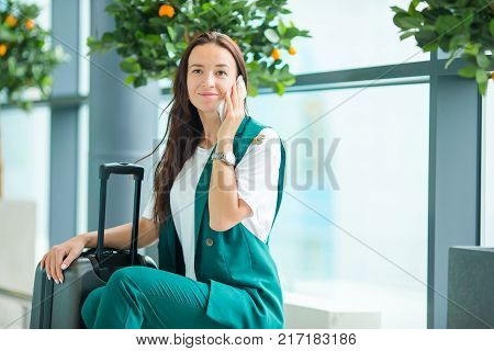 Young woman in international airport walking with her luggage.