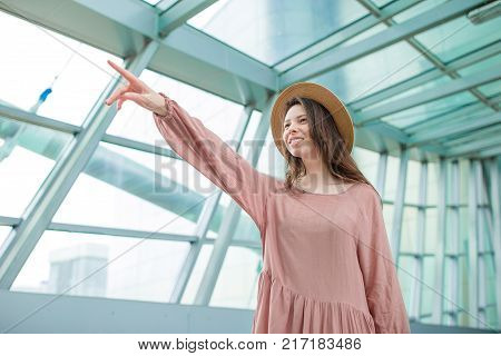 Young woman in international airport walking with her luggage.