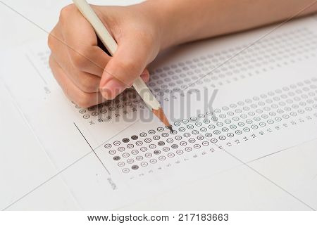 woman's hands filling in standardized test form