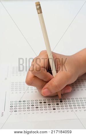 woman's hands filling in standardized test form