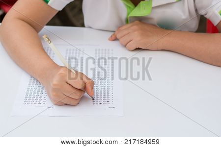 woman's hands filling in standardized test form