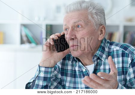 Portrait of a senior man with phonel at home