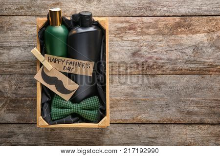 Crate with gifts for Father's day on wooden background