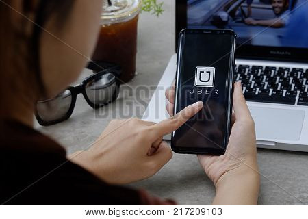 CHIANG MAITHAILAND - DEC 08 2017 : A woman hand holding Uber app showing on Samsung galaxy S8 Plus Uber is smart app-based transportation network for a travel transport.