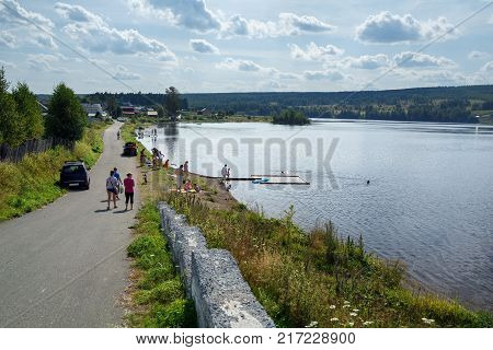 People bathing in the country pond on a hot summer day. Old believer village Visim, Sverdlovsk oblast, Russia.