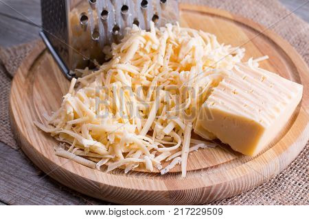 Grated cheese on a wooden cutting board