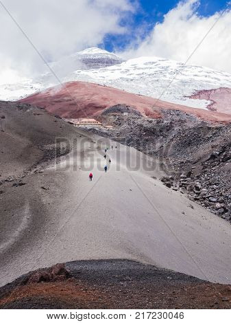 Backpackers climbing Cotopaxi volcano along a pyroclastic rocks hiking trail, Ecuador