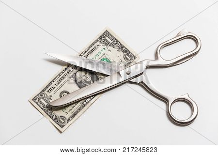 Great tailoring scissors on a denomination one dollar on a white background.