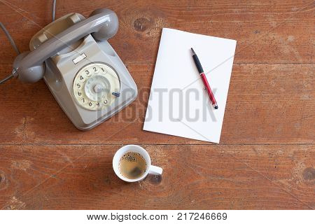Vintage telephone espresso paper pen antique wood background