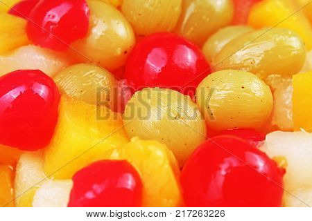 Fruit salad texture. Fruits as background pattern. Exotic Fruits Fruit salad with cocktail cherry sour cherry mango pineapple grapes, pear, maracuja, papaya in syrup. Food.