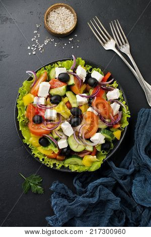 Greek salad in a ceramic plate on a white wooden background. Traditional Greek dish. Selective focus.Top view.