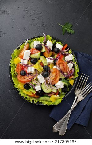 Greek salad in ceramic plate on gray concrete background. Traditional Greek dish. Selective focus.Top view.