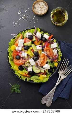 Greek salad in ceramic plate on gray concrete background. Traditional Greek dish. Selective focus.Top view.