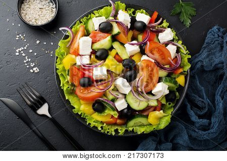 Greek salad in ceramic plate on gray concrete background. Traditional Greek dish. Selective focus.Top view.