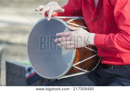 musician plays a traditional drum. Dhol can refer to any one of a number of similar types of double-headed drum widely used, with regional variations, throughout the Indian subcontinent.
