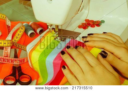 processes of sewing on the sewing machine sew women's hands sewing machine. Female tailor threading leather material on sewing machine