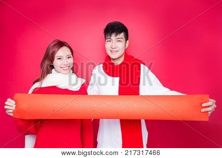 couple show couplets with chinese new year on red background