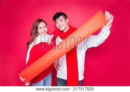 couple show couplets with chinese new year on red background