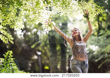 Beautiful happy woman speding time in green nature