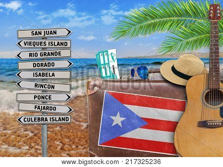 Concept of summer traveling with old suitcase and Puerto Rico town sign