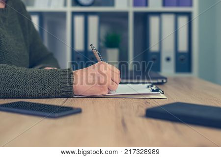 Female entrepreneur signing business contract agreement in home office interior