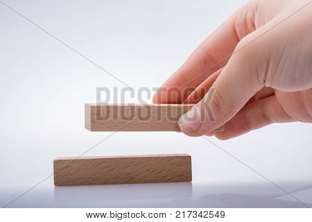 Hand holding wooden domino on a white background