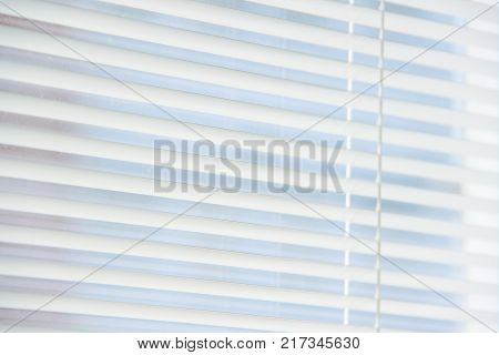 Horizontal white blinds as a background in sunny day