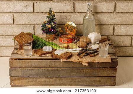 New year's table outdoor. Traditional Ukrainian and Russian snacks in the fresh air. Food with alcohol. Vodka, canned gobies in tomato sauce, smoked fish, sandwiches with bacon and onions.