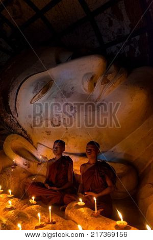 Bagan Myanmar - December 6 2014: Young Buddhism monk praying with candle light at Shwesandaw temple.