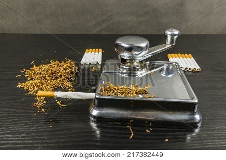 Making cigarettes at home. Feeder for manual application of tobacco cut into short strips into cigarette tubes.
