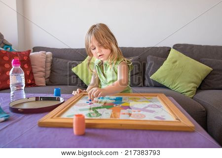 Little Child Playing Parchis Game At Home In Summer
