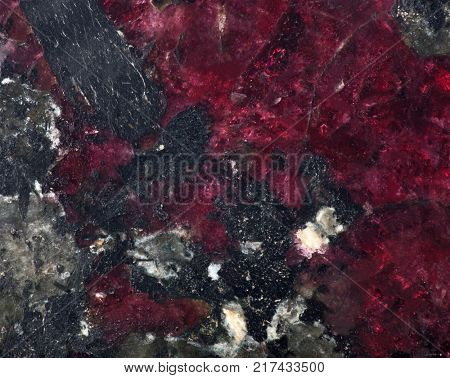 red and black eudialyte mineral texture macro