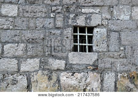 window with a lattice in the stone wall of the old fortress