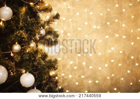 Gold Christmas background of de-focused lights with decorated tree