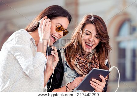 Young friends using tablet and listening music from tablet technology concept.