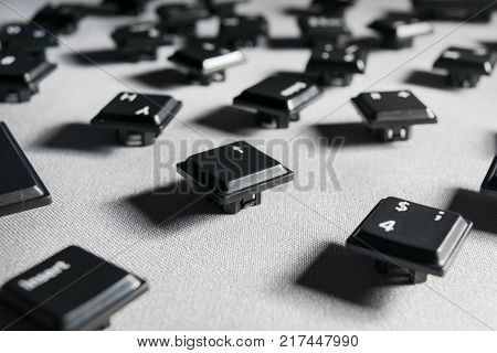 keys from the keyboard scattered on a gray fabric close-up