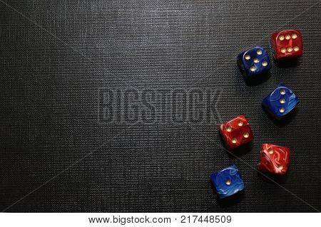 multi-colored dice lying on a black textured surface