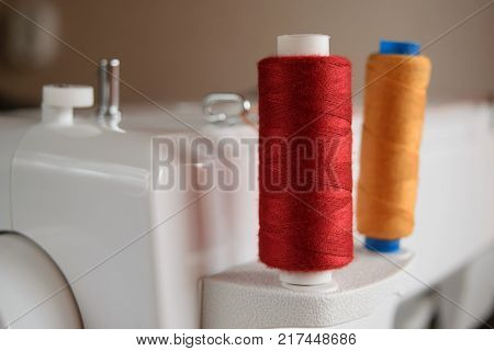 colored thread coils mounted on a pin of a sewing machine