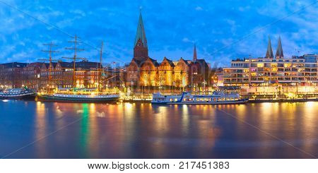 Embankment of the Weser River and Protestant Lutheran Saint Martin Church in the old town of Bremen, Germany. Night panoramic view.