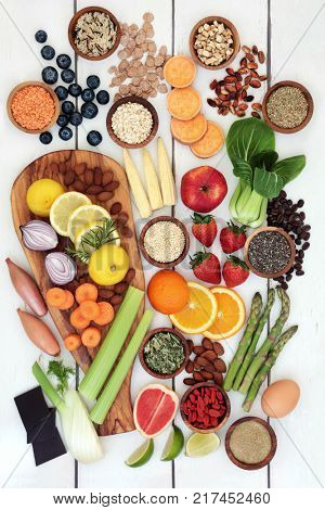 Healthy diet food for weight loss with fresh fruit, vegetables, nuts, seeds, grains, cereals and dairy with herbs used as an appetite suppressant. Top view on rustic background.