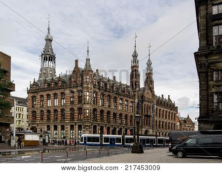 AMSTERDAM NETHERLANDS - NOVEMBER 7 2013: Famous Magna Plaza shopping mall in Netherlands with a blue tram in front of it. The image was taken on November 7 2013.