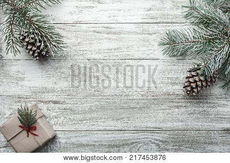 Christmas background with gift box and fir branches on old wooden table. Holidays background. Space for text