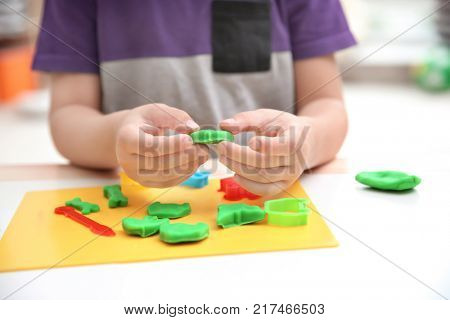 Little boy engaged in playdough modeling at daycare