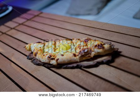 Ajarian traditional flatbread - khachapuri or hachapuri on the wooden table